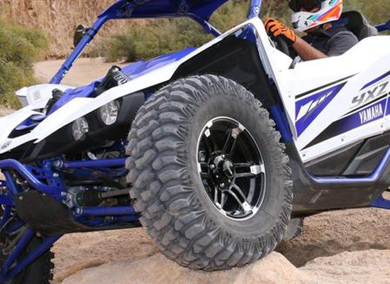 A person in a blue and white buggy on rocks.