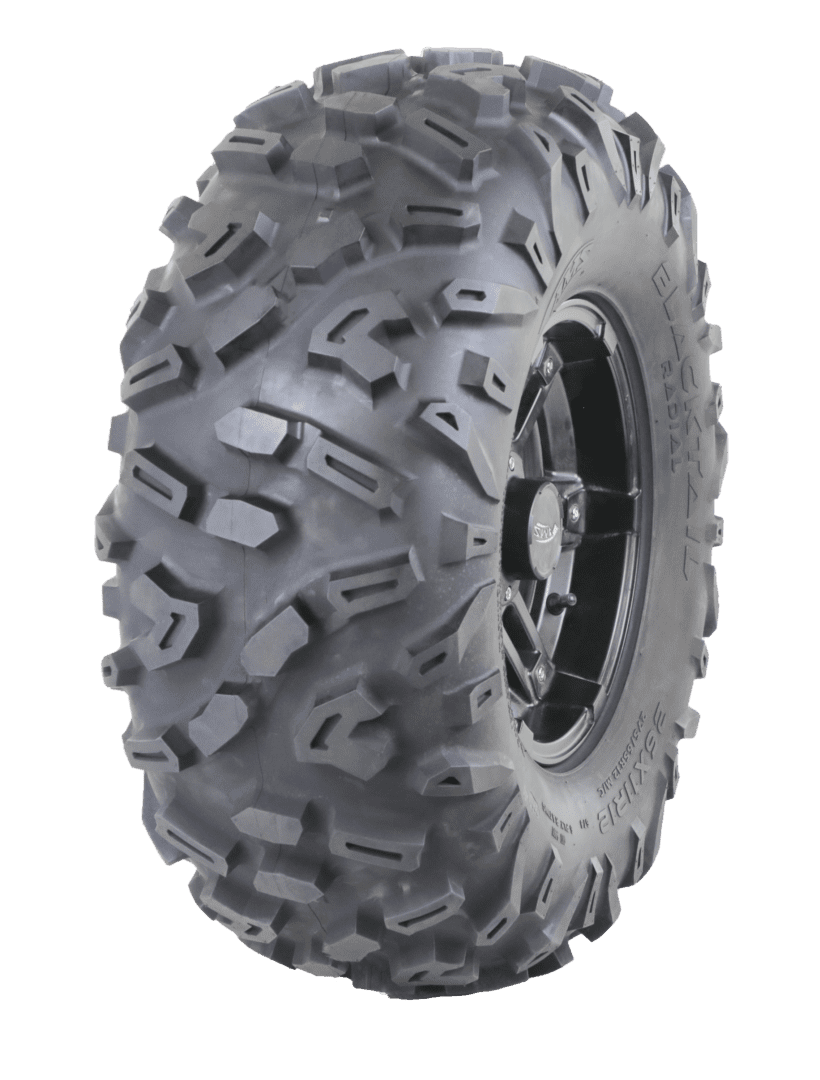 Heavy-duty off-road tire with rugged tread and a silver rim, isolated on a gray background.