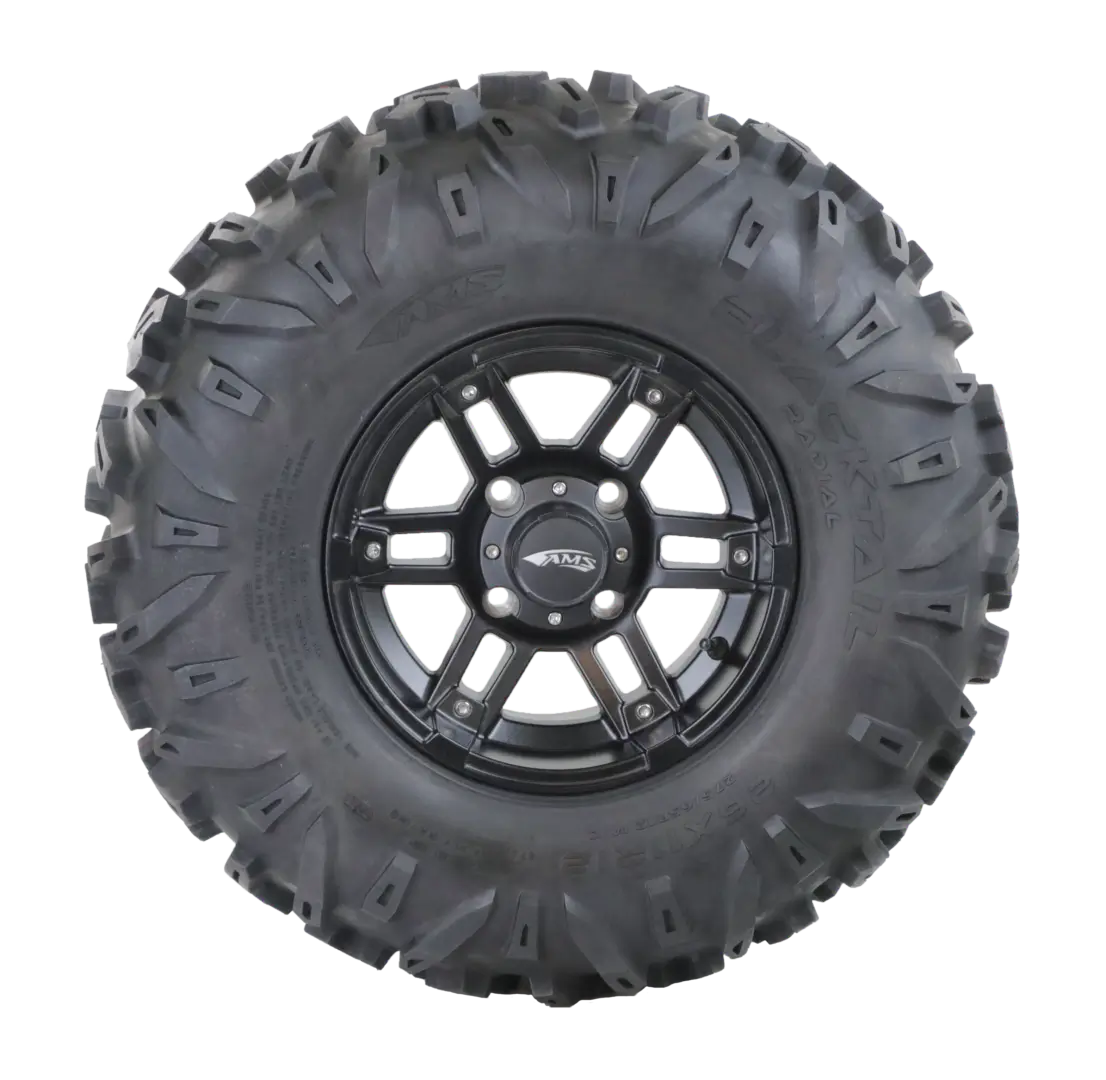 A black all-terrain vehicle tire with a detailed tread pattern and a dark alloy wheel, isolated on a transparent background with faint green stripes.